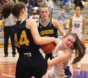 Sophia Baugh of North Kitsap struggles to take the ball away from Maia Greiwe of Bainbridge.