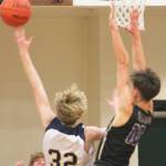 Sam Nyland (32) drives in for a layup against Cade Orness (10) of North Kitsap.