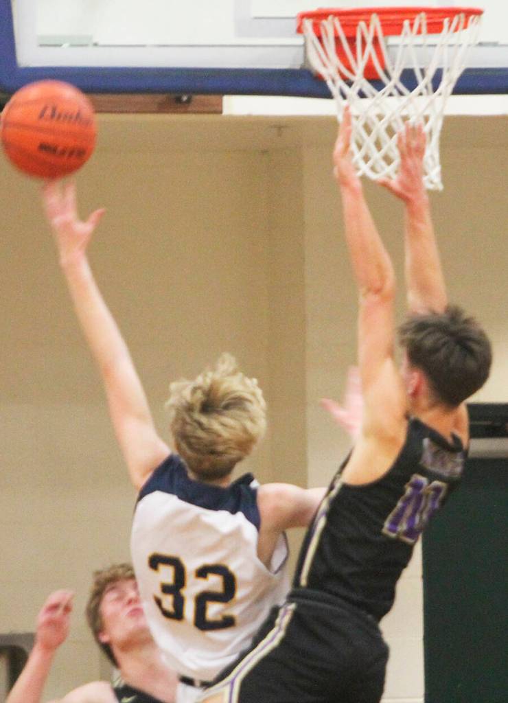 Sam Nyland (32) drives in for a layup against Cade Orness (10) of North Kitsap.