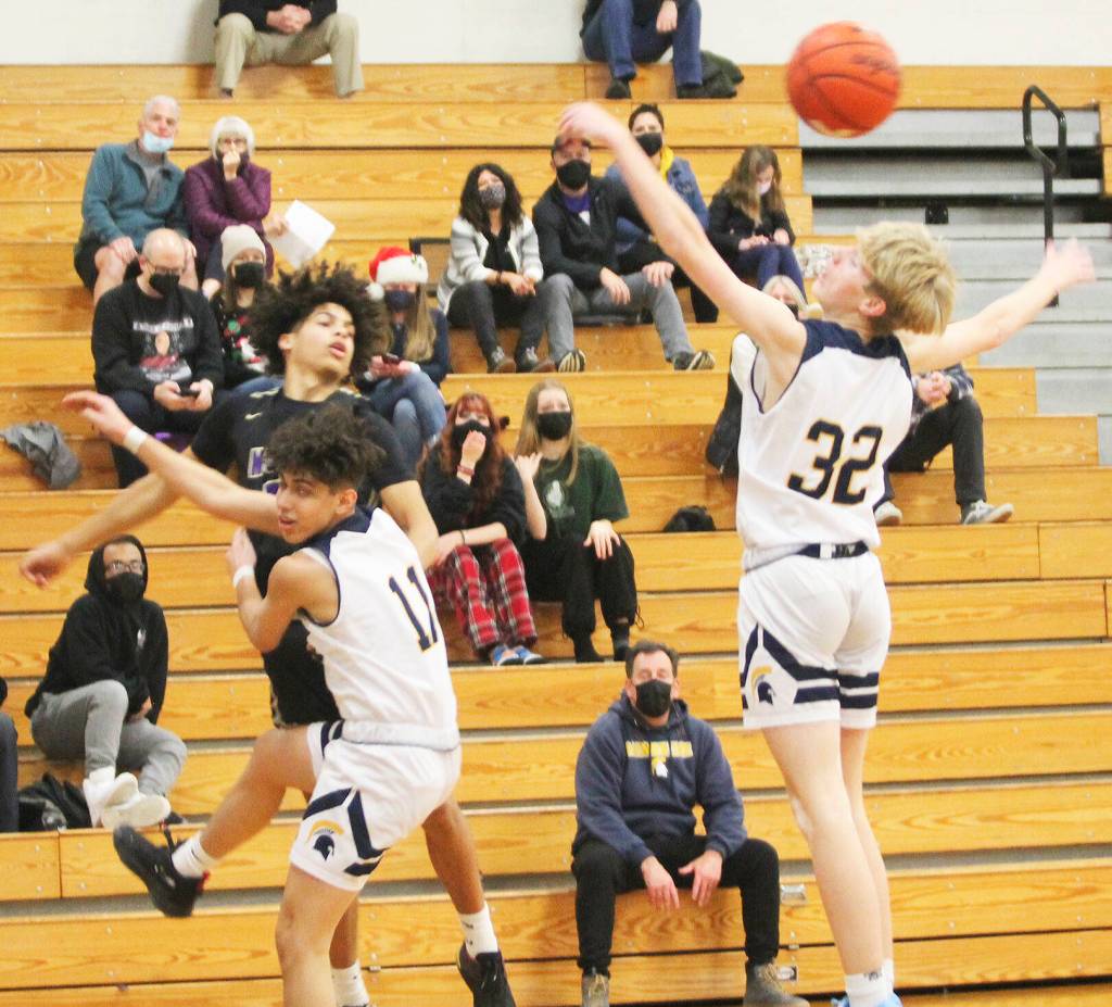 A pass floats over the outstretched arms of Sam Nyland (32) of Bainbridge Island as Breno Ogrui also defends.