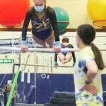 Bainbridge coach Katie Rochon watches as Avery Gray does her routine on the uneven parallel bars, which she won.