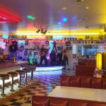 Bob Thompson, owner and curator of My Girl Drive-In and Museum in Kingston, poses on stage with a guitar. Tyler Shuey/Bainbridge Island Review photos