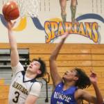 Cliff Hennessey (3) of Bainbridge drives to the hoop against Olympics DArtagnon Gaitor. Steve Powell/Bainbridge Island Review photos