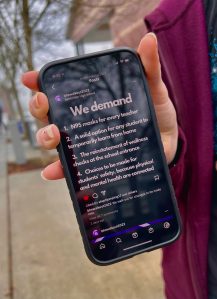 Nancy Treder/Bainbridge Review
A student shows the BHS Walkout 2022 Instagram page that listed demands for student safety.