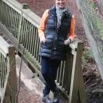 Owner Janice Pedersen at a scenic bridge on the property.