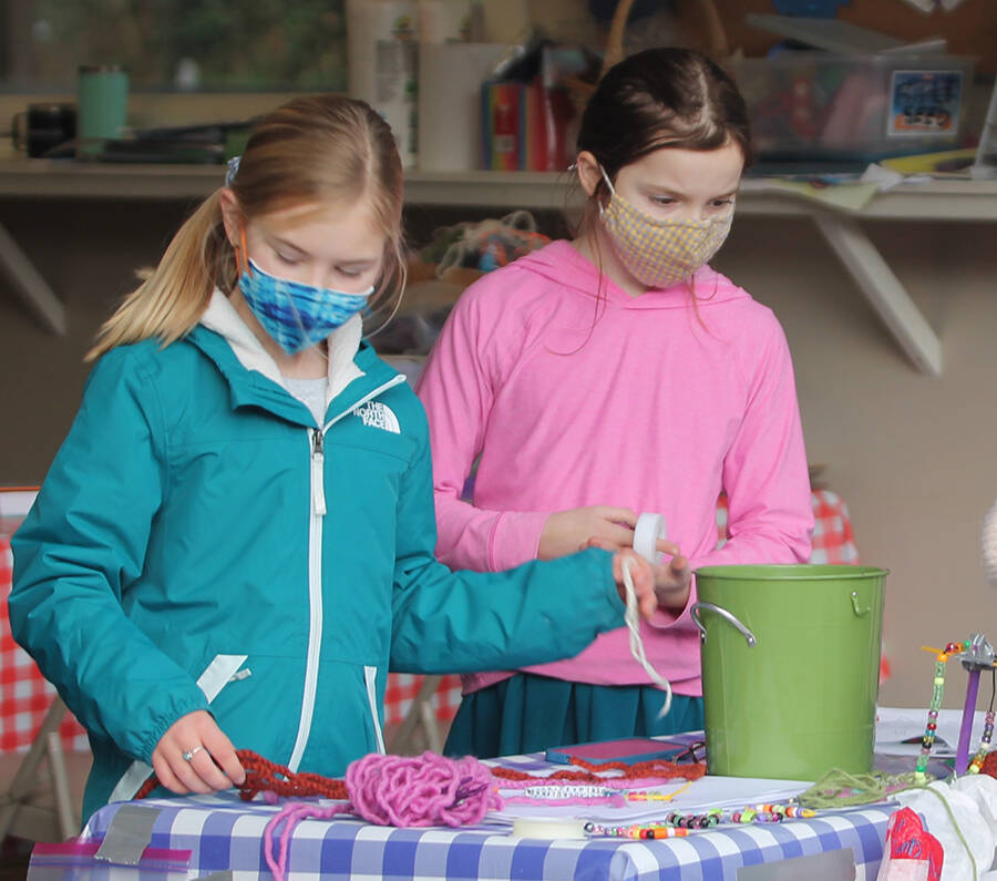 Stella McFarland, left, and the other older students make jewelry for a fundraiser.