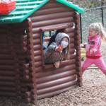 Some girls enjoy a playhouse at the school.