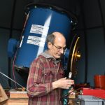 Frank Petrie, Battle Point Observatory Association president, adjusts the telescope alignment.