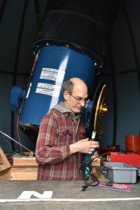 Frank Petrie, Battle Point Observatory Association president, adjusts the telescope alignment.
