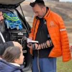 Chabad.org/News courtesy photo
Above: Rabbi Yechiel Shlomo Levitansky and his family, left, talk with paramedics heading to Ukraine. After the rabbi visited with folks via Zoom in Bainbridge his family escaped from the turmoil. At left, Rabbi Mendi Goldshmid, shown here lighting the Menorah, is getting Bainbridge Islanders to help people in Ukraine.