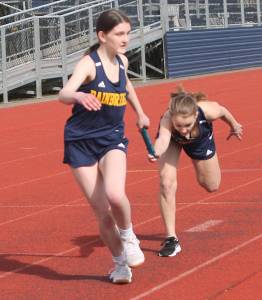 Handoff to second leg of Bainbridge's 4 by 200 relay. Steve Powell/Bainbridge Review