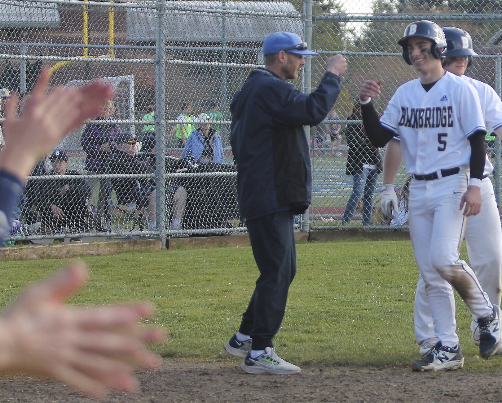 Teammates clap for Coco Black after he scores a run for the home team.