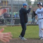 Teammates clap for Coco Black after he scores a run for the home team.