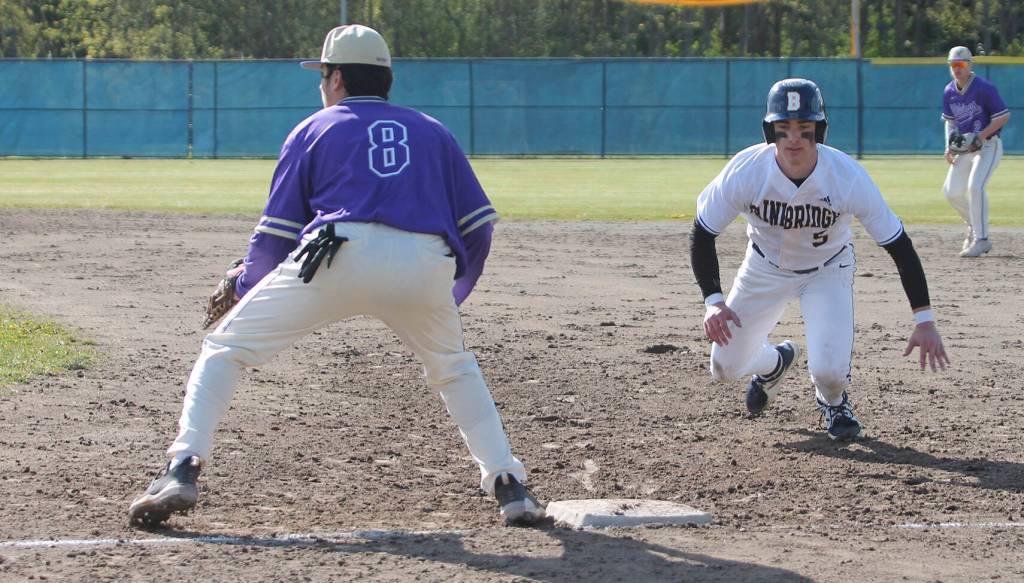 CoCo Black dives safely back to first base after a pickoff attempt. Ethan Gillespie of NK awaits the toss.