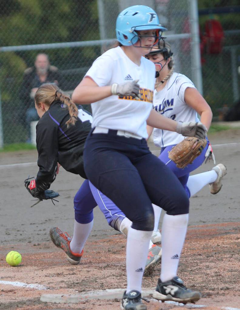 Sequim players scurry after the ball as Spartan Sophia Hoff is safe at first.