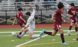 John Roman of Bainbridge does a slide tackle to take the ball away from an opponent earlier this year. Roman is a senior midfielder for the Spartans, who are seeded ninth for the state tournament. Steve Powell/File Photos
