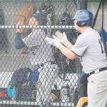 Spartan players and coaches cheer as they score their first run against the Trojans.