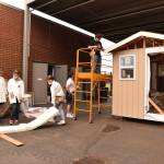 A group of students discuss installing insulation.