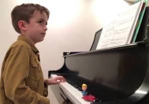 James Pearce Ullrich of Bainbridge Island performs his original composition on the baby grand piano at his home. Courtesy Photo