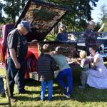 Reid Cunningham and Holden Heatherington, along with Thomas Magin and his mother, Alison Brock, look at a display of toy cars at the show.