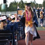 Grace Tuchel give a high five to a fellow graduate after receiving her diplom