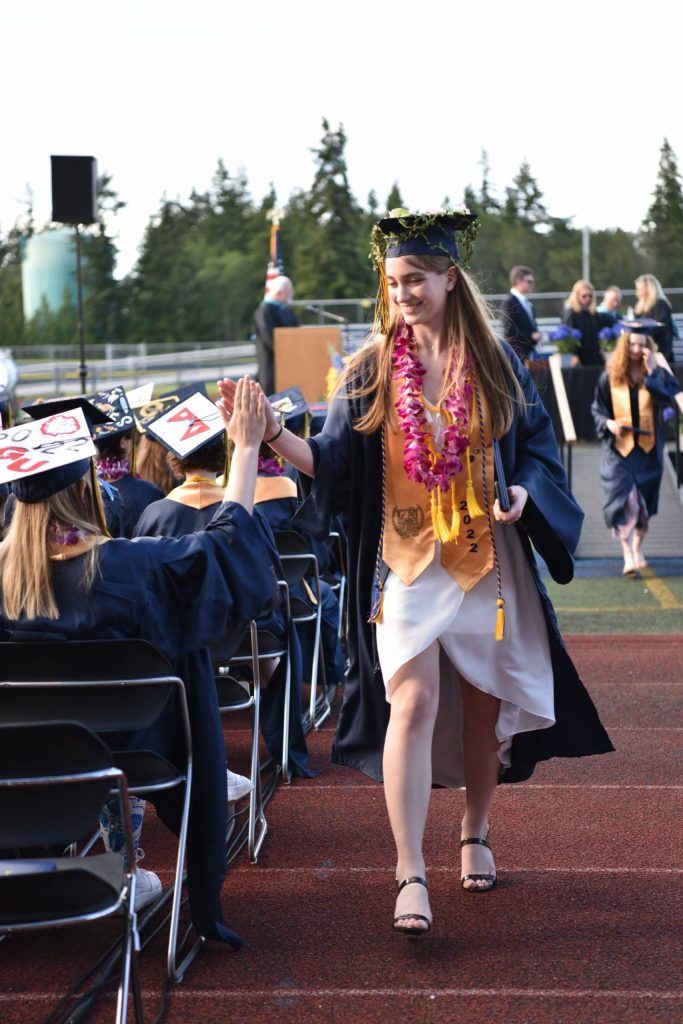 Grace Tuchel give a high five to a fellow graduate after receiving her diplom