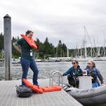 City employees Andreas Kleidouhakis, Carrie Freitas and Jennifer Sutton prepare to board a flotilla dinghy piloted by April Armstrong at the Hidden Cove floating dock to make their way to Suquamish during the Cascadia Rising exercise.