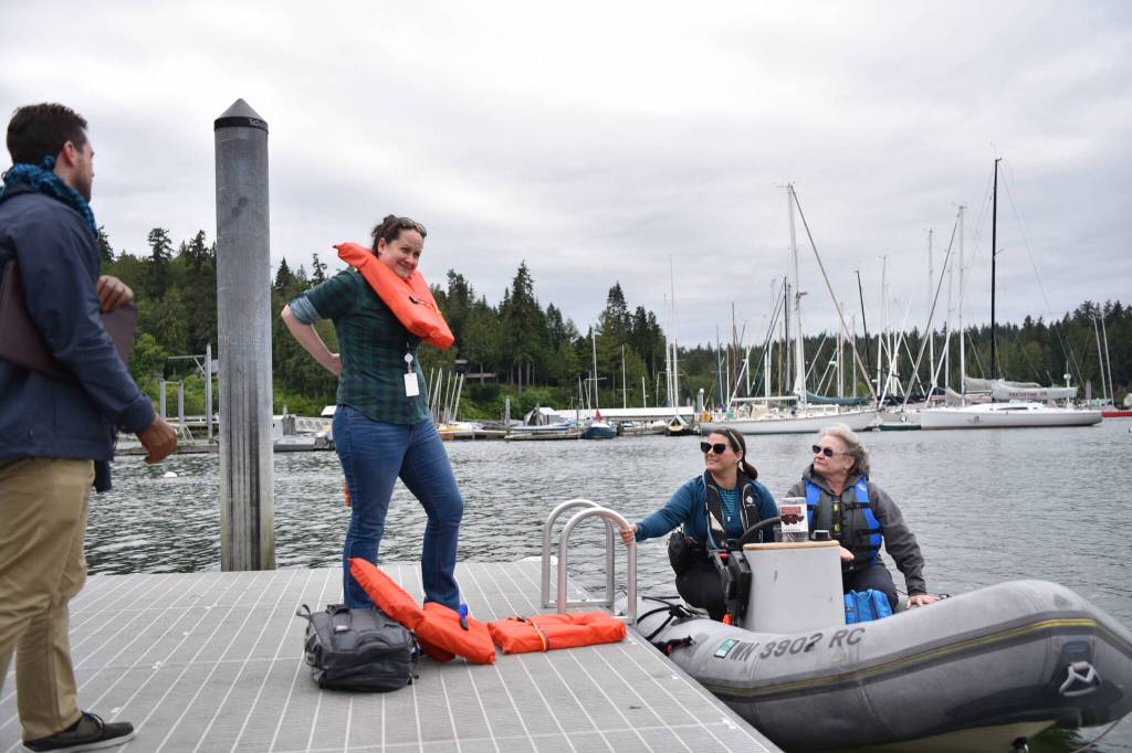 City employees Andreas Kleidouhakis, Carrie Freitas and Jennifer Sutton prepare to board a flotilla dinghy piloted by April Armstrong at the Hidden Cove floating dock to make their way to Suquamish during the Cascadia Rising exercise.