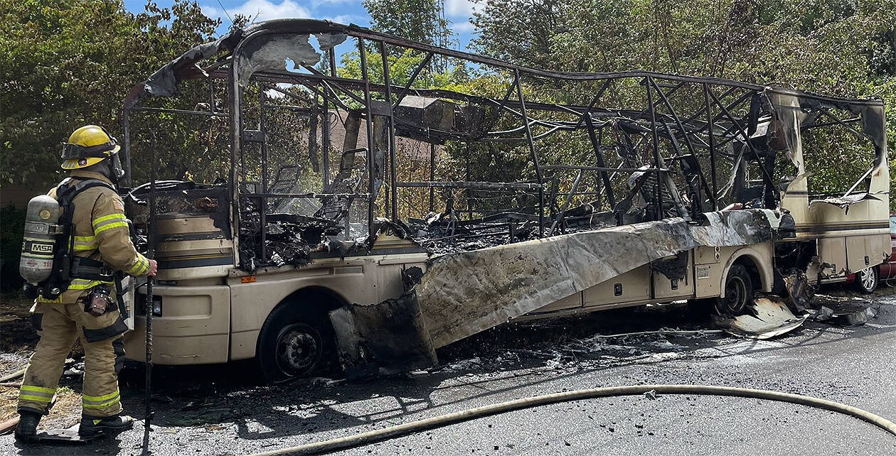 NKF&R firefighter Charlie Hough scans the remains of an RV that burned Tuesday afternoon in Suquamish. Courtesy Photo