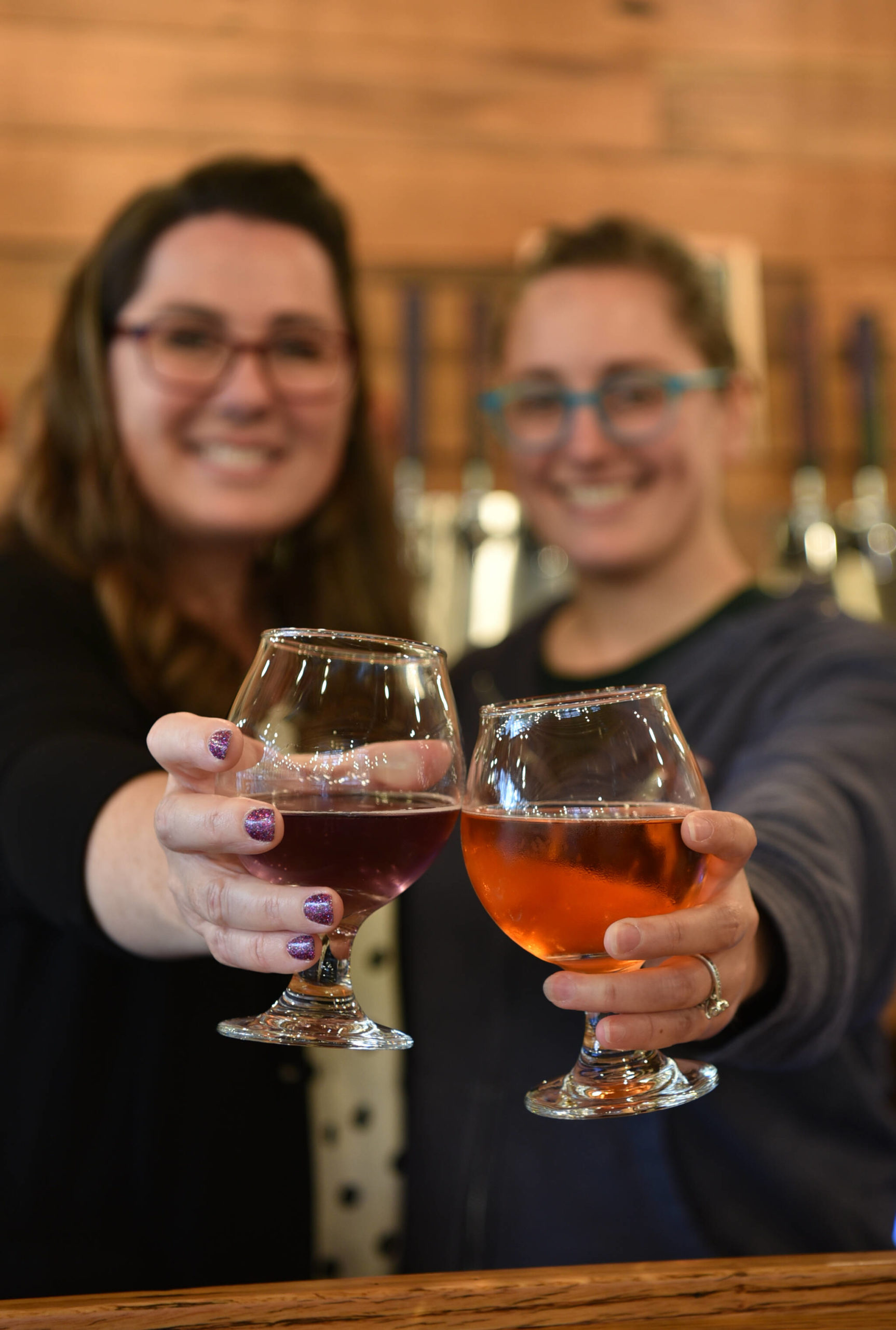 Nancy Treder/Bainbridge Island Review Photos
Above: Co-owners Randi Brown and Caron Anderson toast the opening of their new business, Sisters Cider House. Left: A colorful flight of cider offerings at Sisters Cider House.