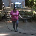 Cast member Carol Stanley sprays down the stage area to prevent dust from flying up at the actors and the audience.