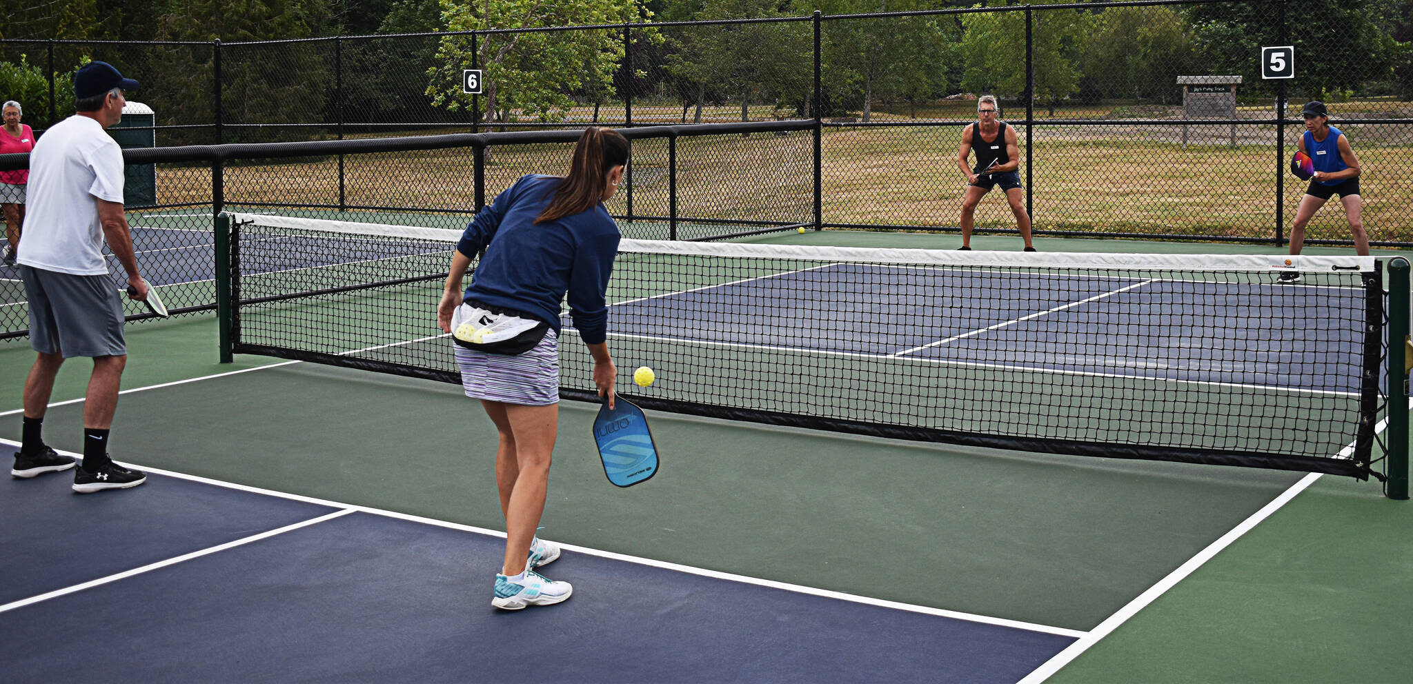 Tonja Major helps Theresa Collier, Marty Collier and Tim Phillips work on staggering positions in case the opponents return a hard-hit ball.
