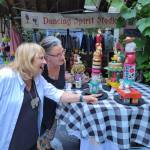 Mixed media artist Dana Watson shows one of her whimsical assemblage pieces to a tour visitor. Courtesy Photos.