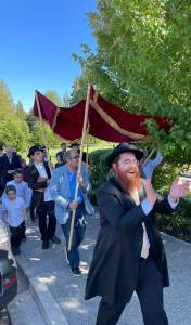 Rabbi Mendy Goldshmid leads a celebration to welcome the new CommUnity Torah at Wilkes Elementary School August 28 in Bainbridge Island. Courtesy photos