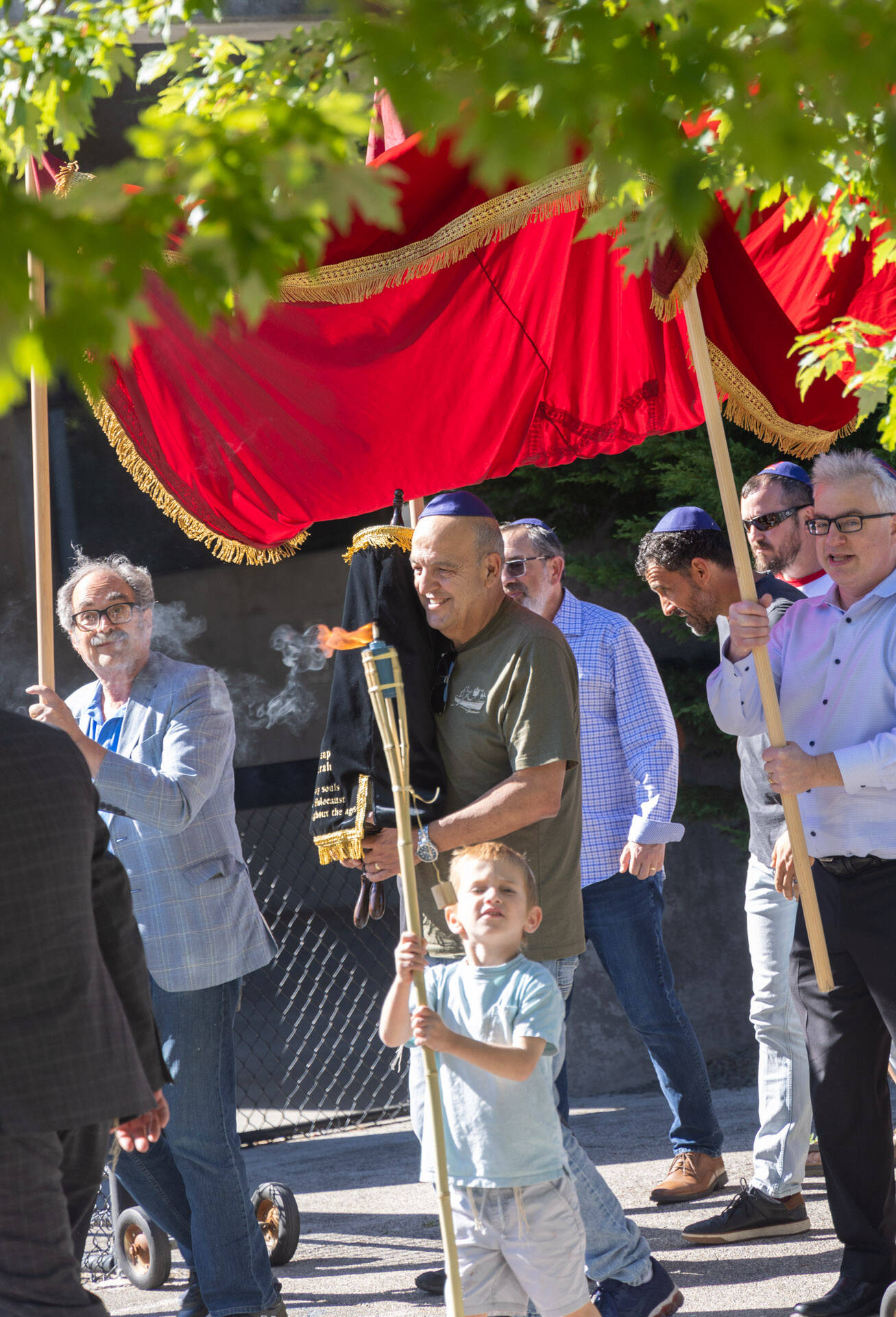 The Torah is carried under a canopy in a joyful march that includes music, torches and dancing.