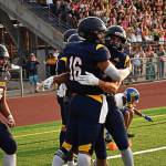 Jack Grant celebrates with teammates after the first touchdown of the season.