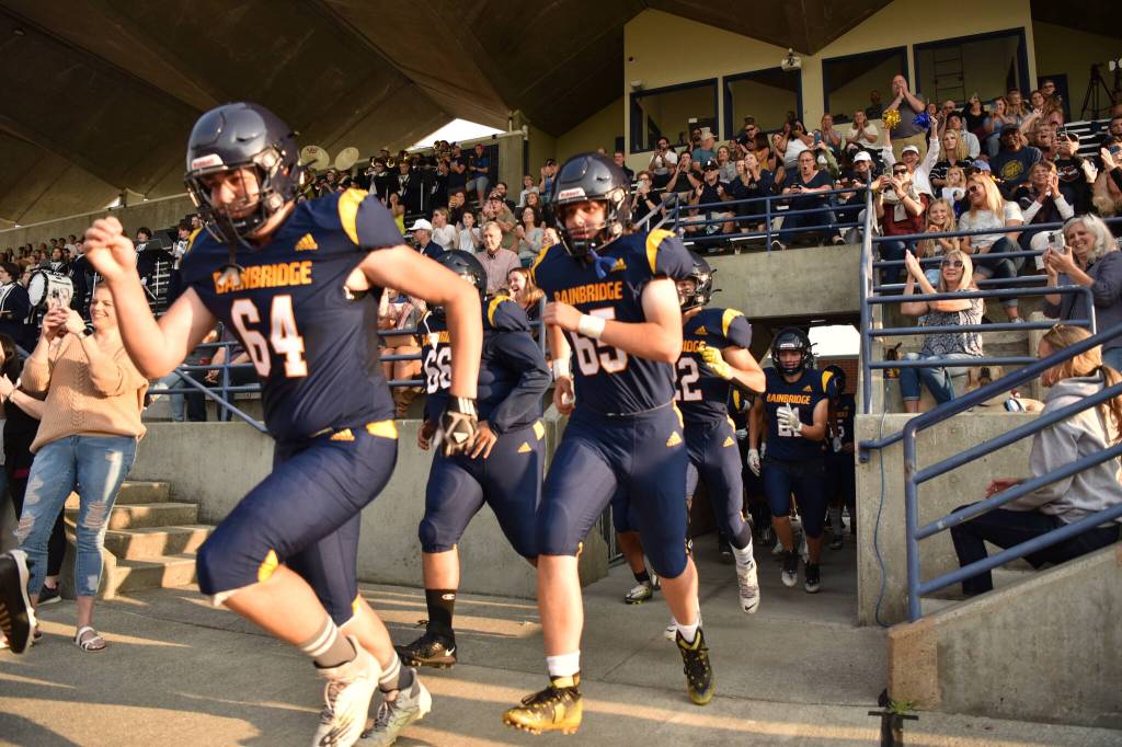 Spartan juniors Grady Nordstrom (64) and Connor Maddie (65) rush to the field before the game starts.