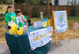 Bainbridge Island sisters Cece and Maggie Meiers raised $670 in two hours Sept. 4 to pay tuition for three children to attend school at the Flower of Hope Outreach Middle School in Clory, Haiti.  Cece said she thought of the kids in Haiti as her friends and imagined that "they'll be super happy to get to go to school and learn and have fun." The girls are students at St. Cecilia Catholic School. Nancy Treder/Bainbridge Island Review