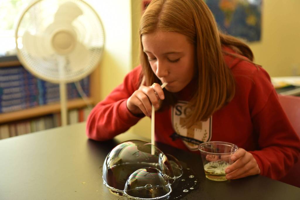 St. Cecilia eighth-grader Megan Zahumenshy conducts a bubble experiment on new lab tables in science class on the first day of school.