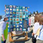 Marvalee Nance explains the details of her "Bee Quilt" based on Bainbridge Island. Nancy Treder/Bainbridge Island Review Photos