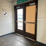 An exit door is repaired after a passenger broke it with a backpack while refusing to leave the terminal area Sept. 5.