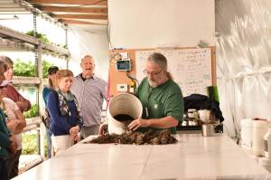 Mark Taylor shows visitors the process he uses to start plants in his hydroponics shed. Nancy Treder/Kitsap News Group Photos