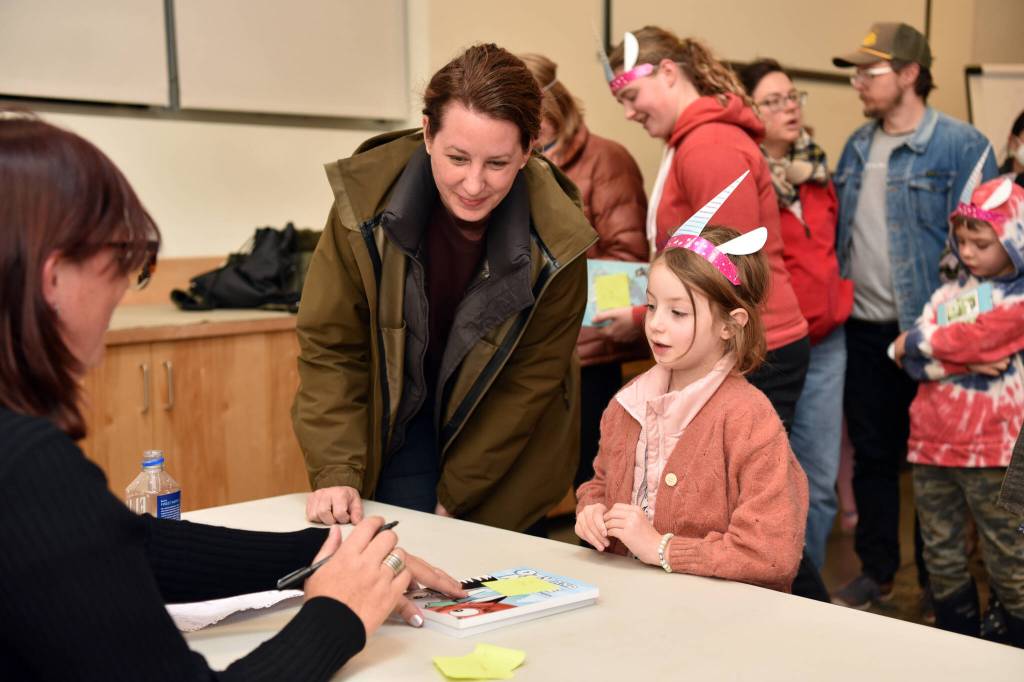Kate Harwood and Evie Williamson get a book signed by visiting author Dana Simpson.