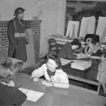 Japanese residents of Bainbridge Island register while a soldier stands by on March 25, 1942. (Paul Wagner / The Associated Press)