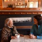 Frances Kitamoto Ikegami and Carol Reitz sit for tea in front of the fireplace where Japanese Islanders were forced to register for exclusion in 1942. Nancy Treder/Kitsap News Group
