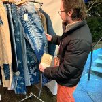 Aidan Terry admires a pair of cyan print pants at the Terra Prints booth.