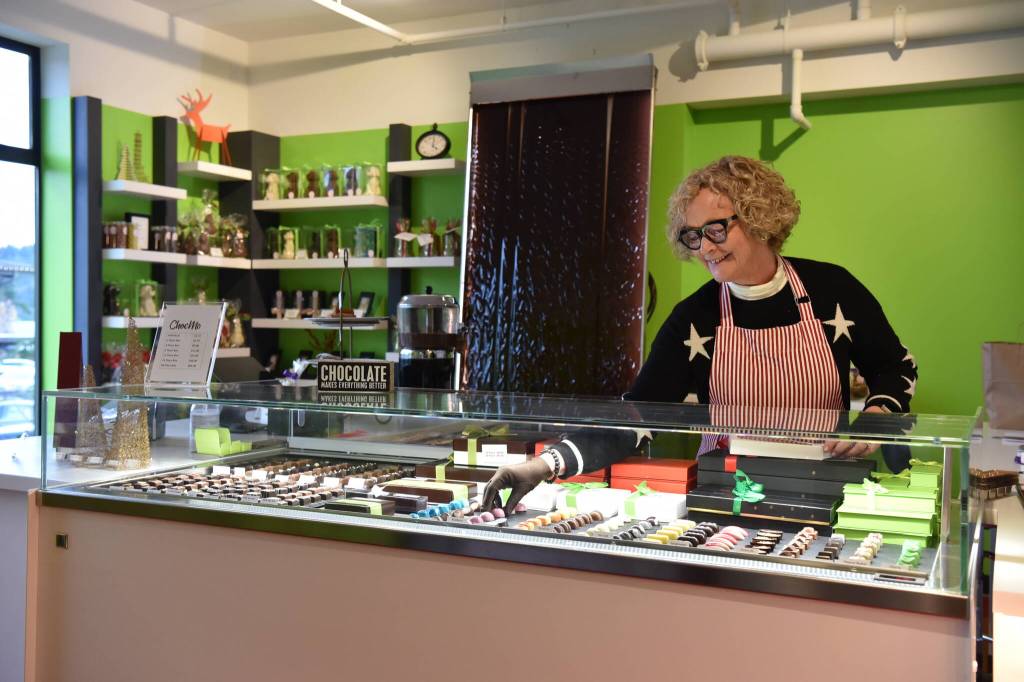 Fiona Ronyai, head of retail operations at LAtelier TR, fills the display case with bonbons and chocolate confections.