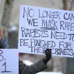 A protester outside the Kitsap County Superior Court holds a pair of signs calling for justice in favor of victims of sexual assault and rape.