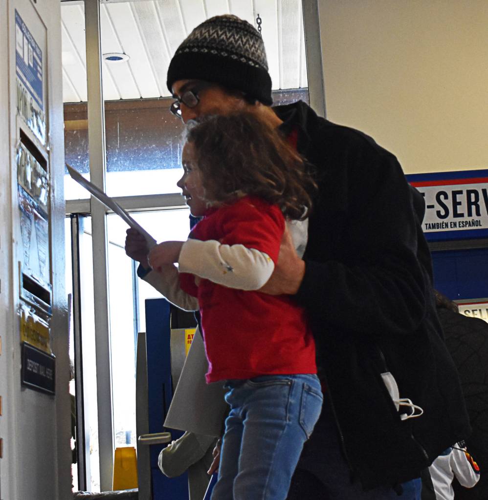 A father lifts his daughter to mail a peace letter at the Bainbridge Island Post Office in Winslow for the Young Peoples March for Peace and Kindness Jan. 16.