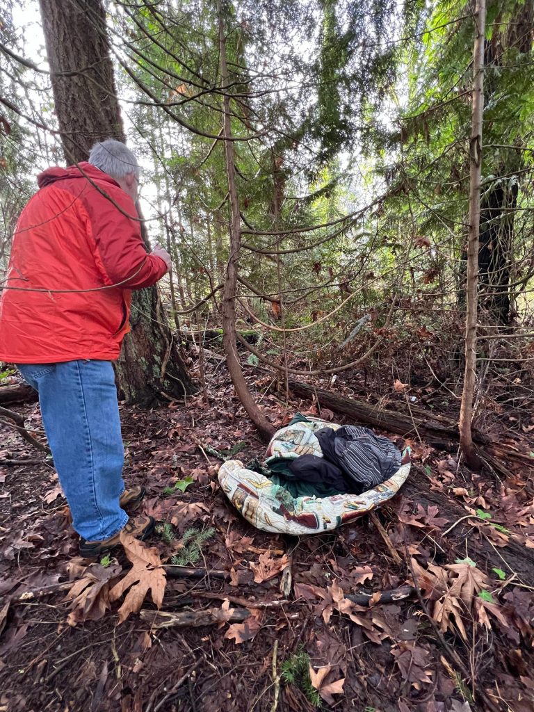 John Dembowski takes a closer look at a sleeping spot in a park in Poulsbo.